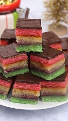 a white plate topped with lots of different colored desserts on top of a table