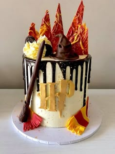 a harry potter themed birthday cake on a white plate with red and yellow flags around it