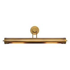 a brass colored light fixture on a white wall with a circular metal bar in the middle