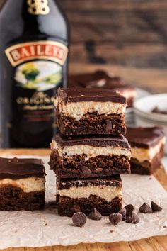 some brownies stacked on top of each other in front of a bottle of beer