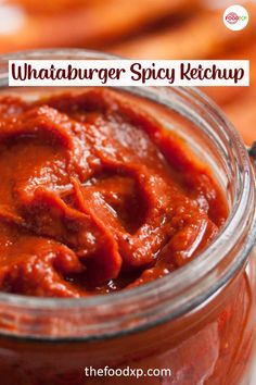 a jar filled with red sauce sitting on top of a table