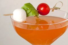 a martini with tomatoes, mozzarella and basil garnish