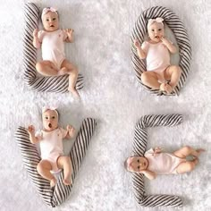 four baby dolls laying on top of a black and white striped blanket in the shape of letters