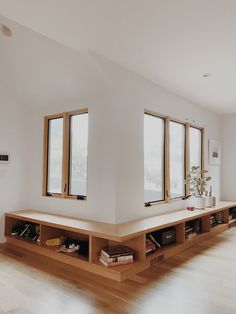 an empty room with windows and bookshelves on the floor in front of them