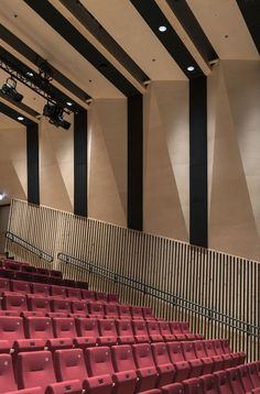 an empty auditorium with rows of red seats