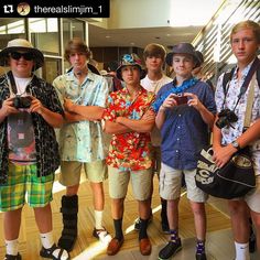 a group of young men standing next to each other in front of an escalator