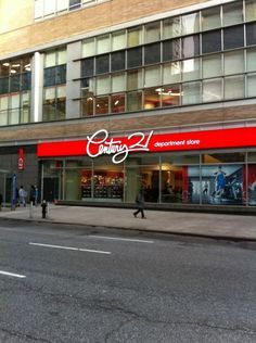 an empty street in front of a building with red and white lettering on the side