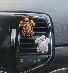 a car air vent with two turtle decorations on it's front grille and the center console