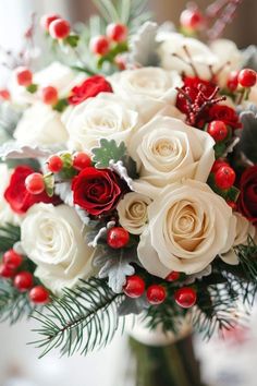 a bouquet of white and red roses in a vase with greenery on the side