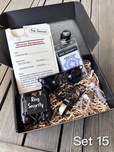 an open box with items inside sitting on a wooden floor next to a sign that says king security