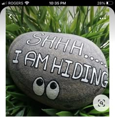 a rock with the words shh i am hiding painted on it sitting in some grass