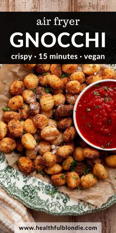 a plate full of fried gnocchini next to a bowl of marinara sauce