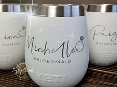 three bridesmaid wine glasses sitting on top of a wooden table with sparkles