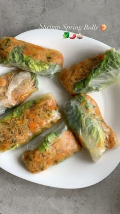 there are many rolls on the plate with lettuce and carrots in them