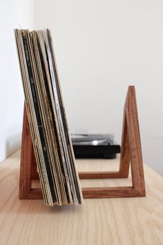 a stack of records sitting on top of a wooden table