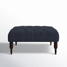 an upholstered bench with wooden legs and dark blue fabric, on a white background