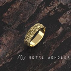 a gold wedding ring on top of a wooden surface with the words metal wenderr written