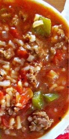 a close up of a bowl of soup with meat and vegetables in it on a table