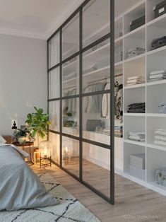 a bedroom with white walls and shelves filled with clothes, candles and other items on the floor