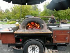 an outdoor pizza oven on the back of a truck