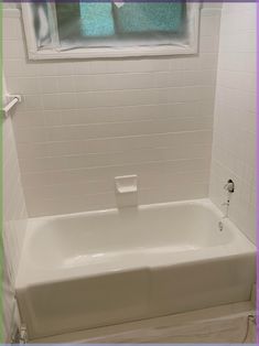 a white bath tub sitting under a window