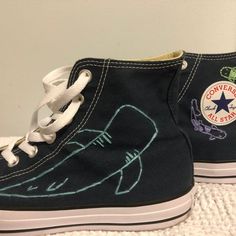 a pair of blue converse sneakers with an image of a shark on the side