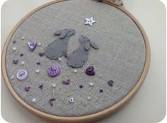 a close up of a embroidery on a wall hanging with buttons and other things to sew