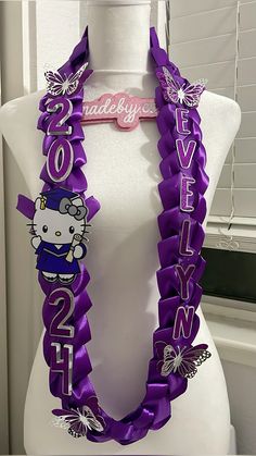 a white mannequin with purple ribbon and hello kitty on it's neck