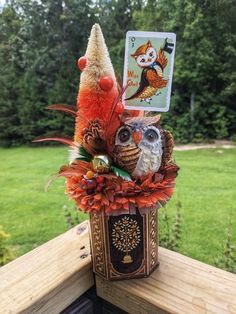 an owl sitting on top of a wooden table next to a tarot card holder