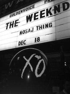 a sign that says the weeknd in front of a building with an xo on it