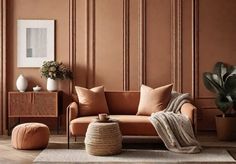 a living room with an orange couch and potted plants on the side table in front of it