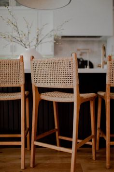 three wooden chairs sitting next to each other in a kitchen