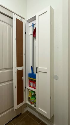 an empty pantry with the door open and cleaning supplies in it's storage compartment