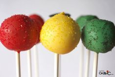 three lollipops with different colors and designs on them are lined up in a row