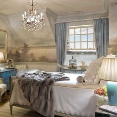 a bedroom with a chandelier hanging from the ceiling and paintings on the walls