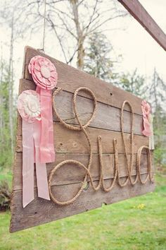 a wooden sign with ribbons hanging from it's sides and the word bridal spelled out in cursive writing