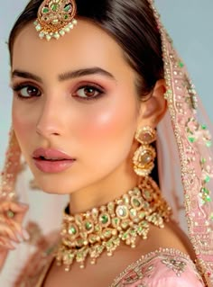 a woman in a pink dress with jewelry on her head