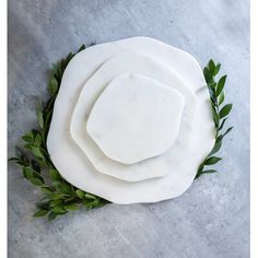 four pieces of white marble with green leaves around them on a gray surface, top view