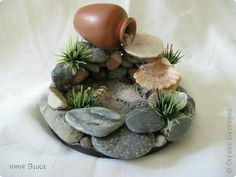 there is a small pot on top of some rocks