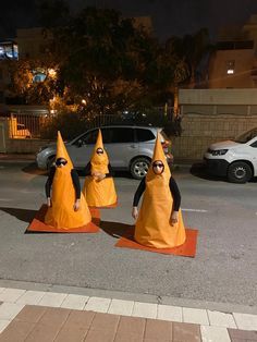 three people in orange cones on the street