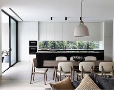 a living room filled with furniture next to a kitchen