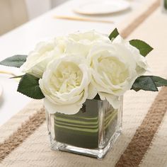 there is a vase with white flowers on the table