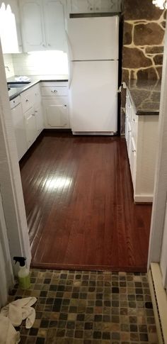 a kitchen with wood floors and white appliances