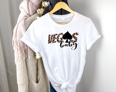 a t - shirt with the words necs baby on it hanging up against a wall