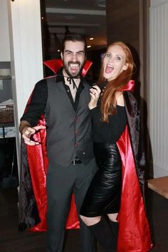 a man and woman dressed up in costumes posing for the camera with capes around their necks