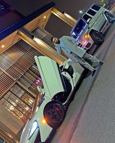 a man standing next to a white car on the street