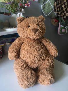 a brown teddy bear sitting on top of a table