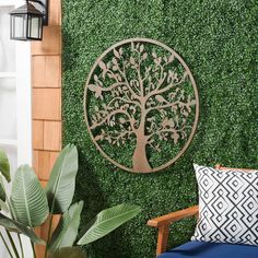 an outdoor wall decoration with a tree on it