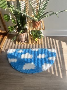 a blue and white rug sitting on top of a wooden floor next to a potted plant