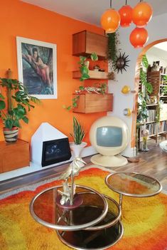 a living room with an orange wall and colorful rugs on the floor in front of it